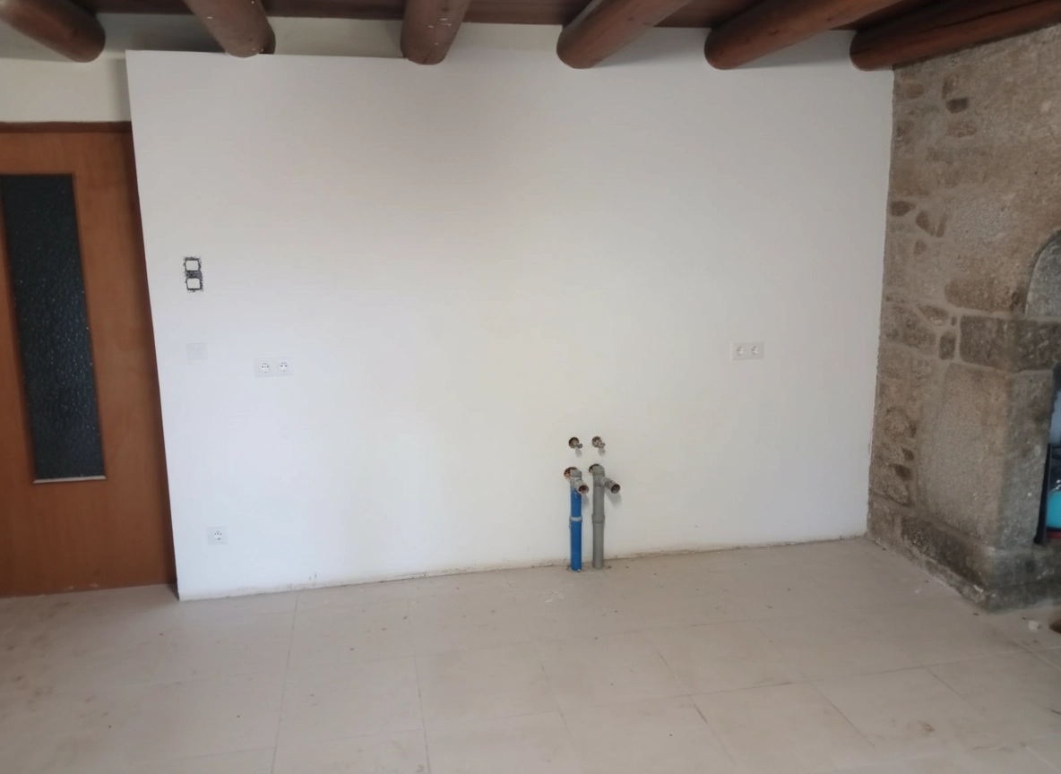 Avant : mur vide avec arrivées deau apparentes, avant installation de la cuisine